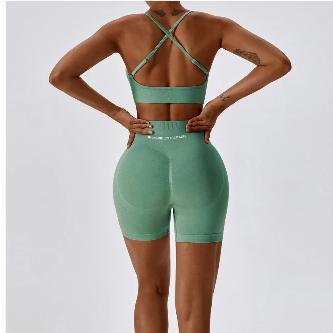 Woman in green seamless sports bra and shorts set, back view, studio background