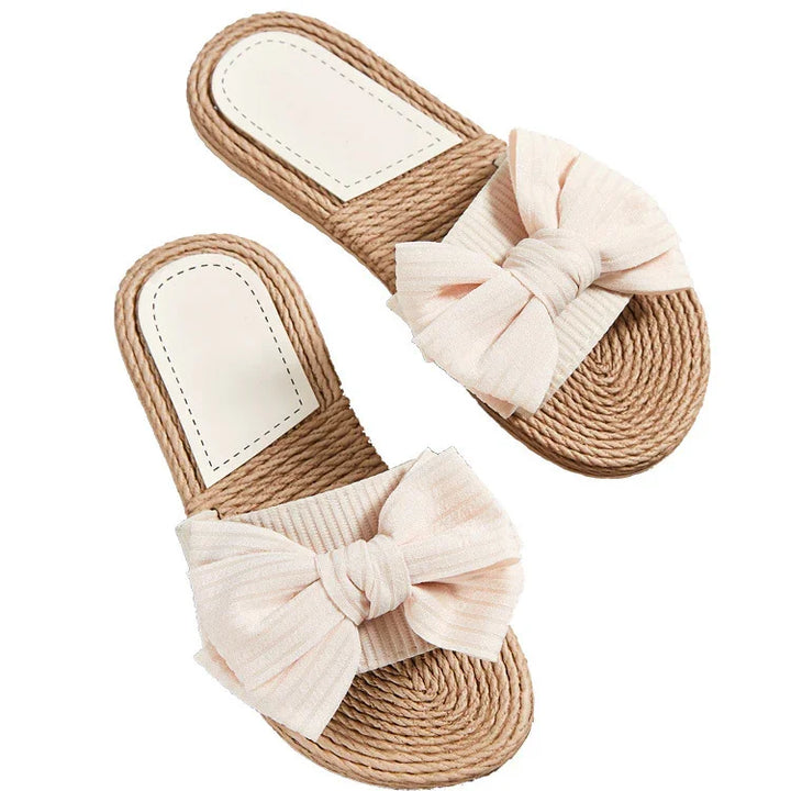 Women's woven straw slide sandals with large beige fabric bow and cushioned footbed