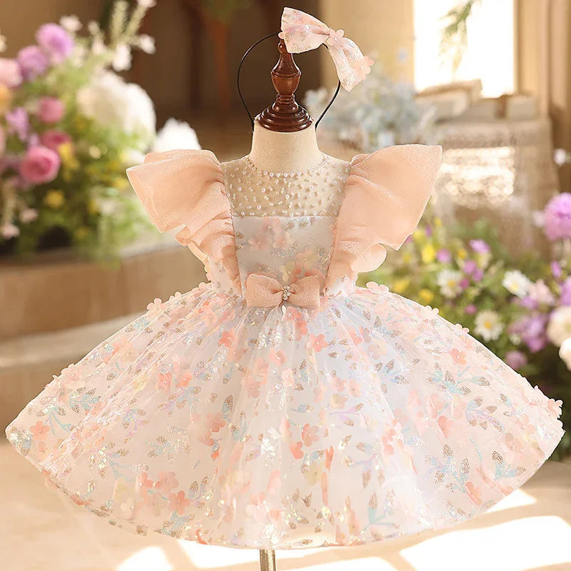 Elegant baby girl dress with puff sleeves, floral pattern, bow detail, and matching headband on mannequin