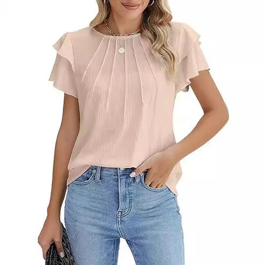 woman wearing light pink ruffle short sleeve blouse with pleats, paired with blue jeans