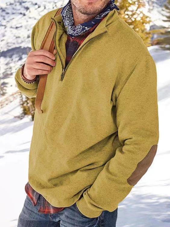 Man wearing mustard fleece pullover with elbow patches and bandana in snowy outdoor setting