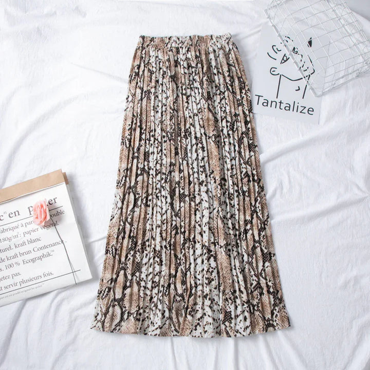 Animal print pleated maxi skirt laid on white fabric with magazine and wire basket nearby