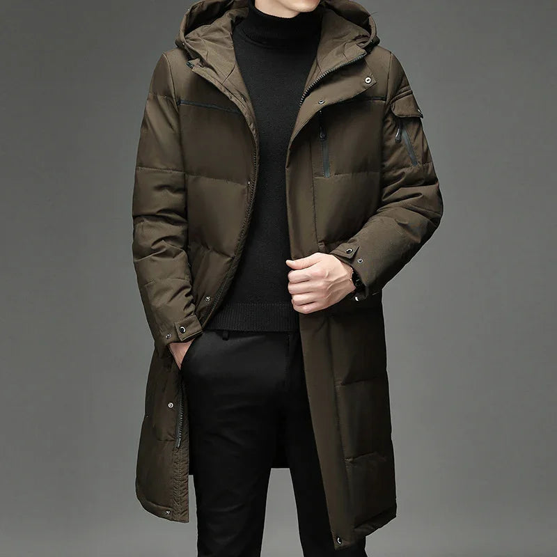 male model wearing long olive green padded winter coat with hood and black turtleneck sweater