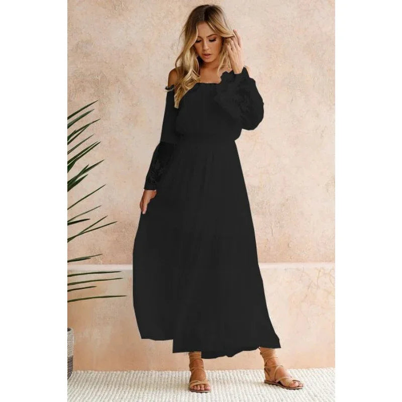 Woman wearing a long black off-shoulder maxi dress with long sleeves and sandals indoors