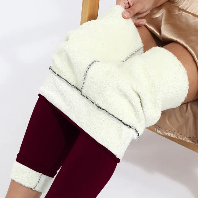Woman wearing maroon leggings with thick white fleece lining, lifting fleece layer over thighs