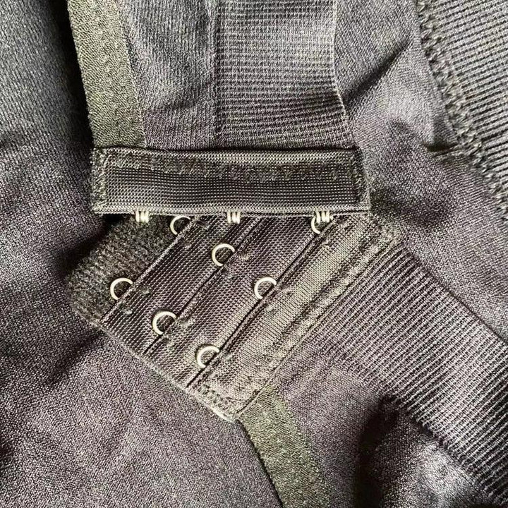 Close-up of black fabric with metal hook-and-eye closures and elastic ribbed band