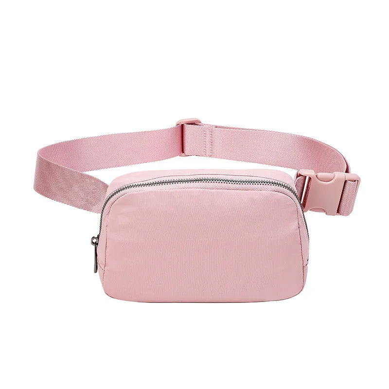 Pink fabric waist bag with silver zipper and adjustable strap on white background