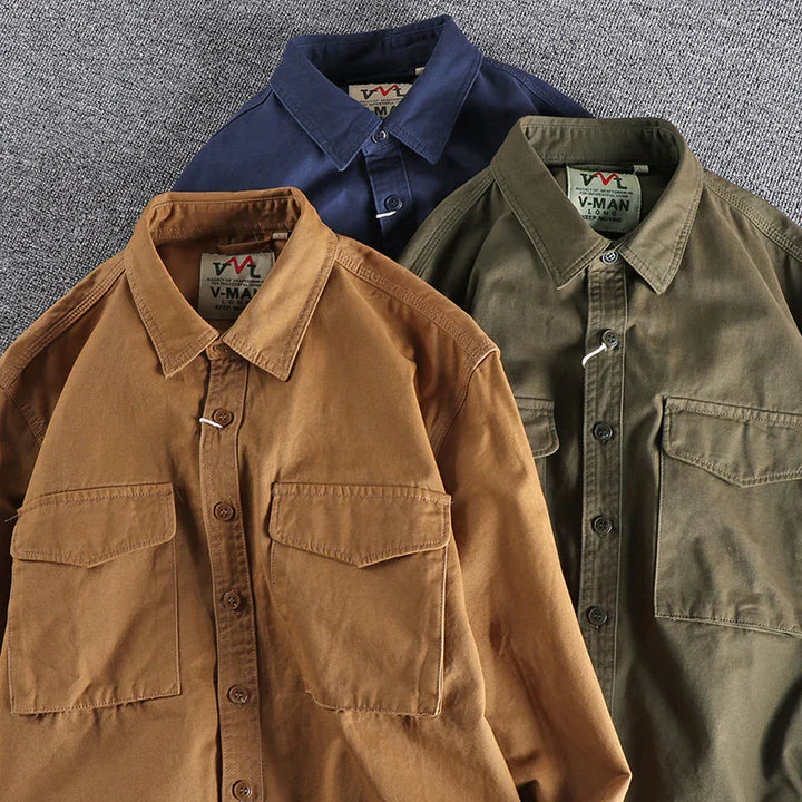 Three men's button-up shirts in brown, olive green, and navy blue with chest pockets on grey background