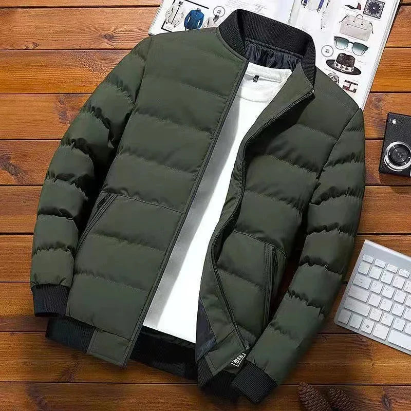 Green padded bomber jacket with black ribbed collar and cuffs displayed on wooden surface with white t-shirt inside