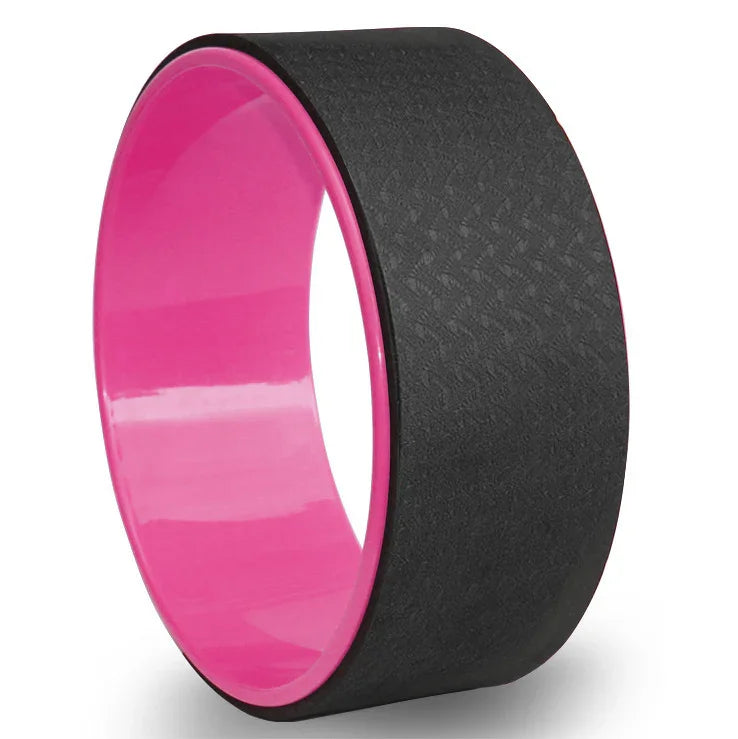 Black and pink yoga wheel with textured surface for stretching and balance exercises