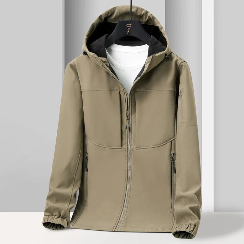 Beige hooded softshell jacket with zipper pockets and black inner lining on hanger