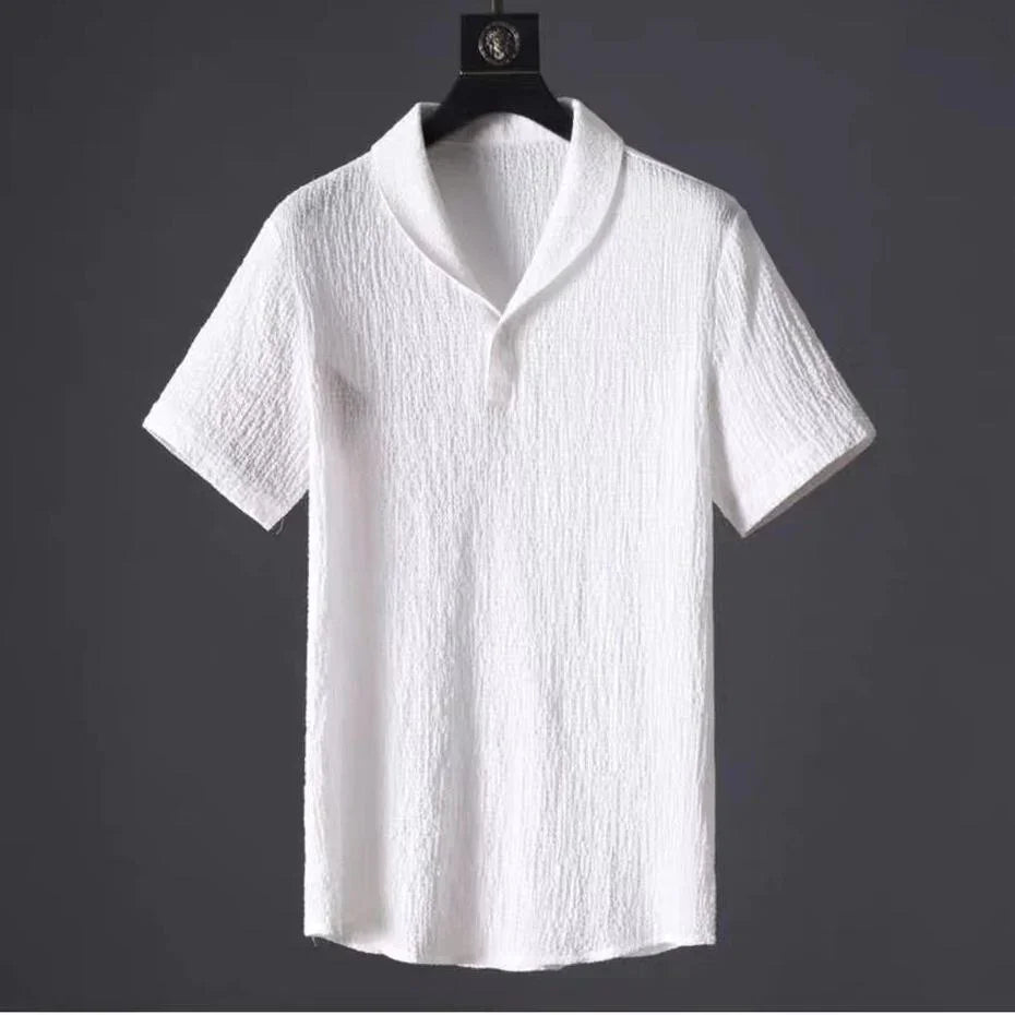 White textured short sleeve shirt with shawl collar hanging on black hanger against dark background
