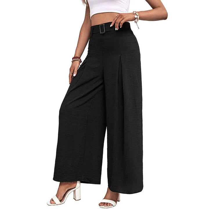 Woman wearing high-waisted black wide-leg pants with belt and white heeled sandals