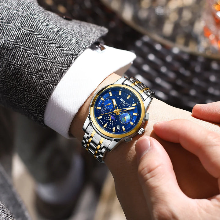Mens luxury wristwatch with blue dial, gold accents, and silver-gold metal band on wrist