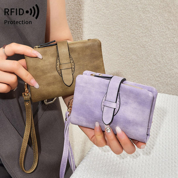 Two women's wristlet wallets in brown and lavender suede with strap and RFID protection