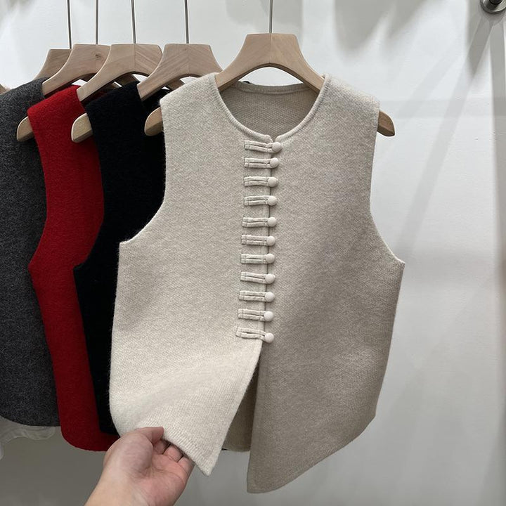 Wool sleeveless vests on wooden hangers in cream, black, red, and dark gray with front button closures