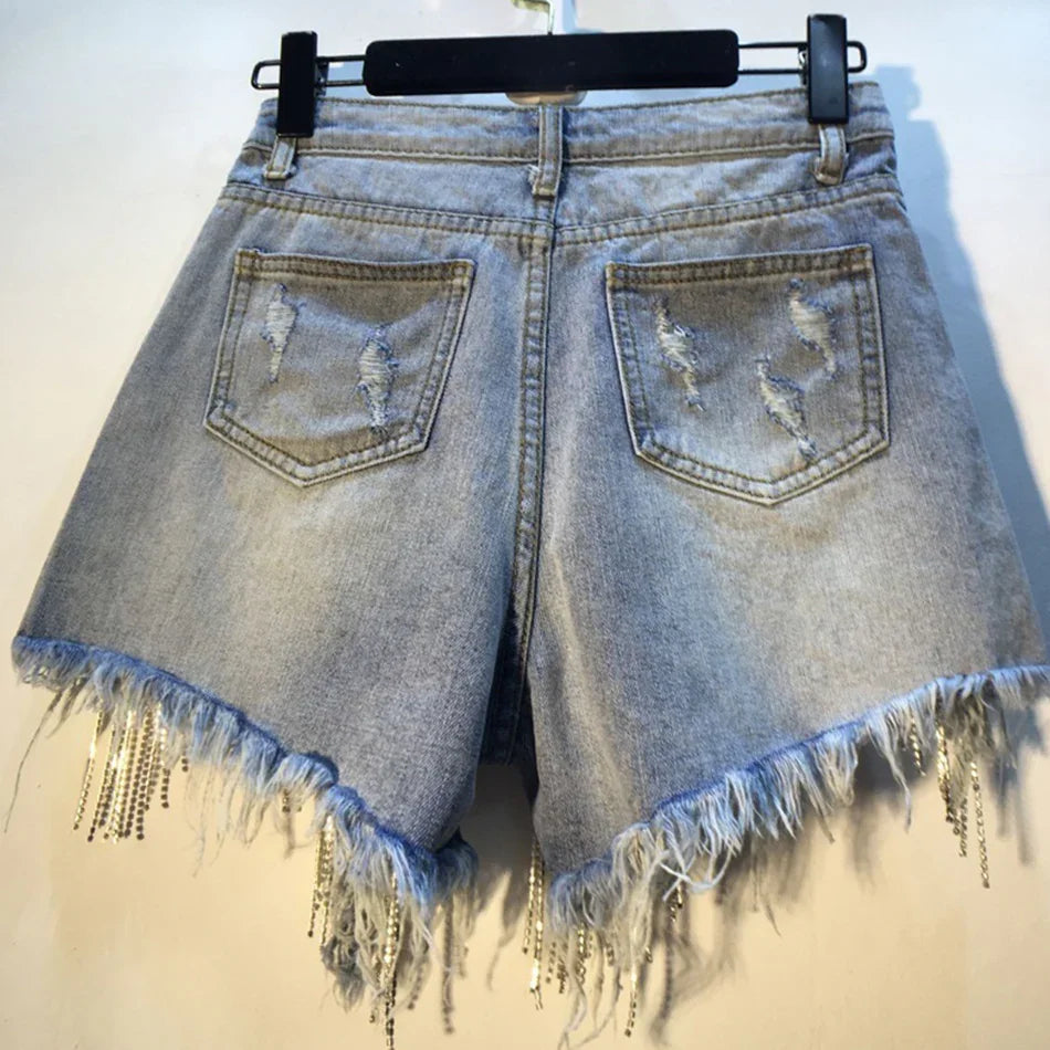 Back view of distressed light blue denim shorts with frayed hems and rhinestone chain details