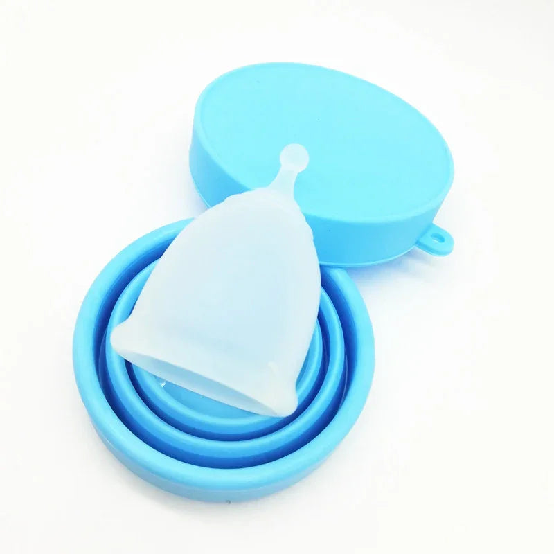 Clear silicone menstrual cup with blue collapsible storage case on white background