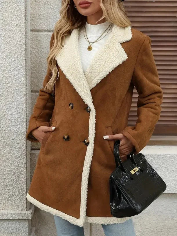 Woman wearing brown shearling coat with cream fleece collar and trim, holding black handbag