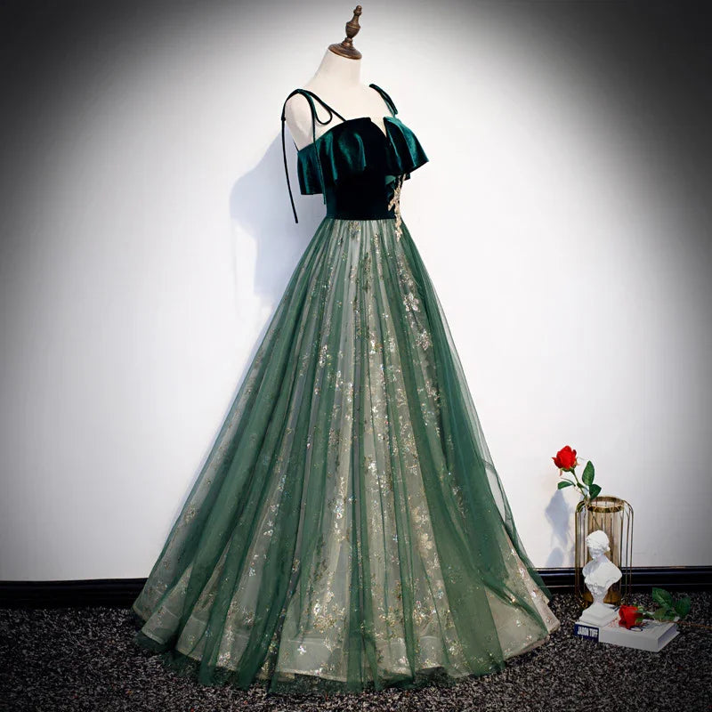 Elegant green evening gown with ruffled velvet bodice and floral embroidered tulle skirt on mannequin