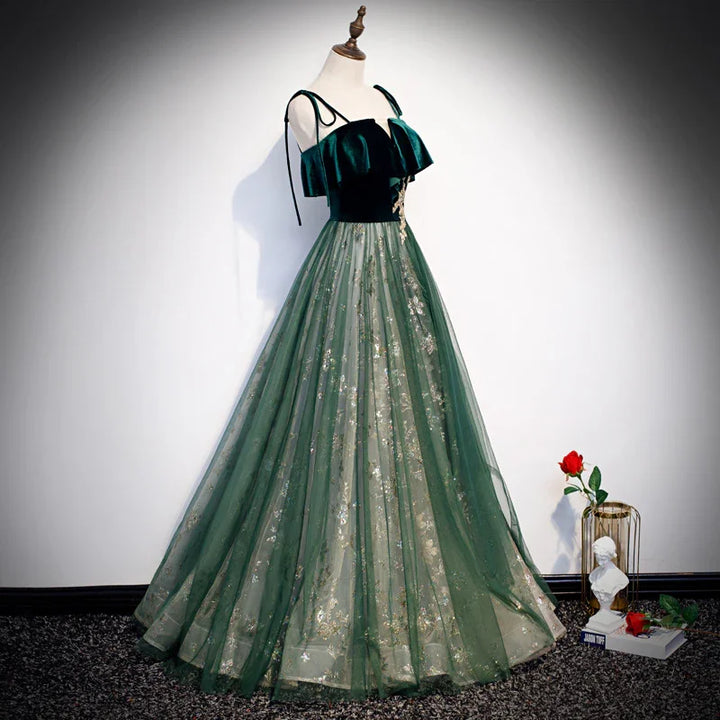 Elegant green evening gown with ruffled velvet bodice and floral embroidered tulle skirt on mannequin