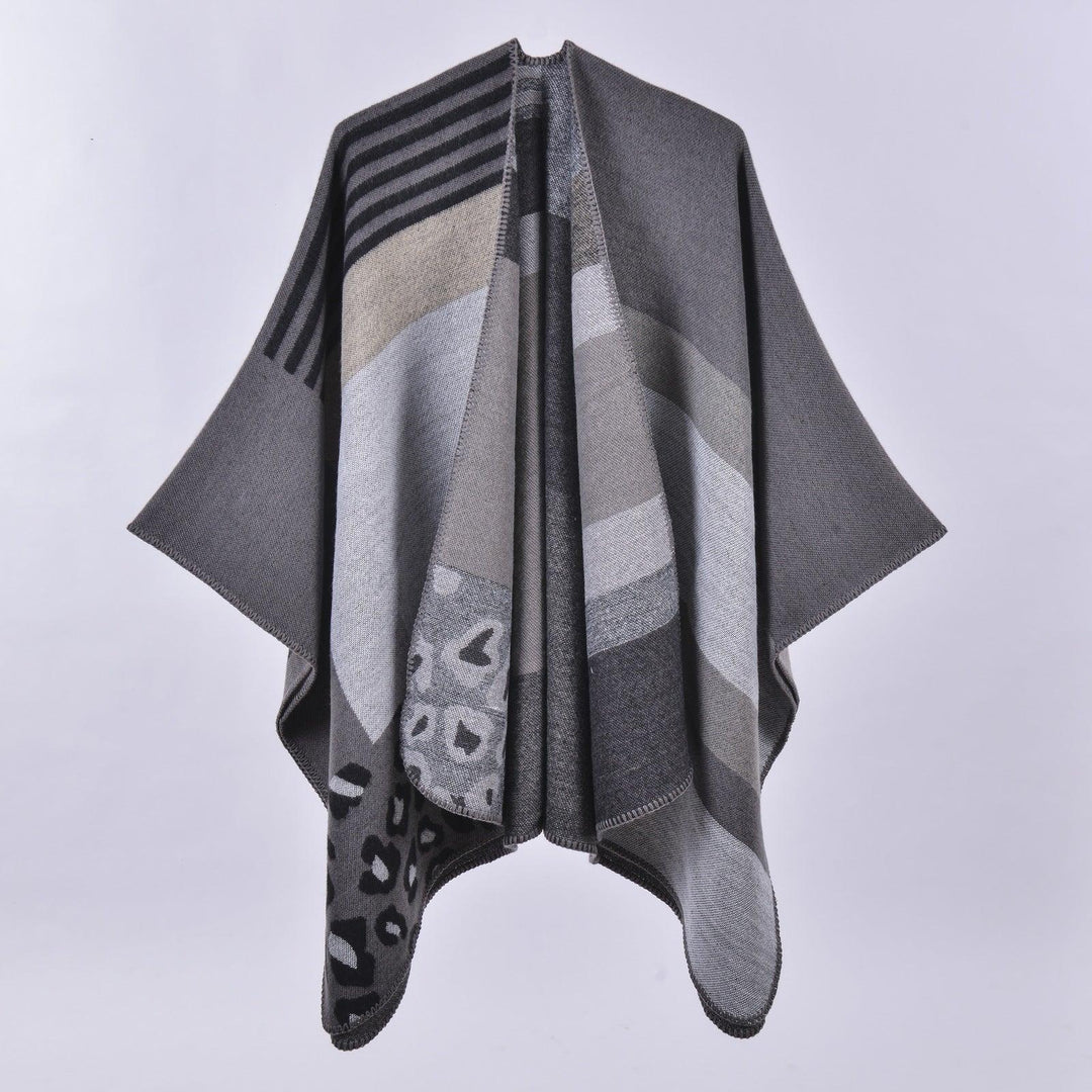 Gray and beige knit poncho with geometric and animal print patterns displayed on white background