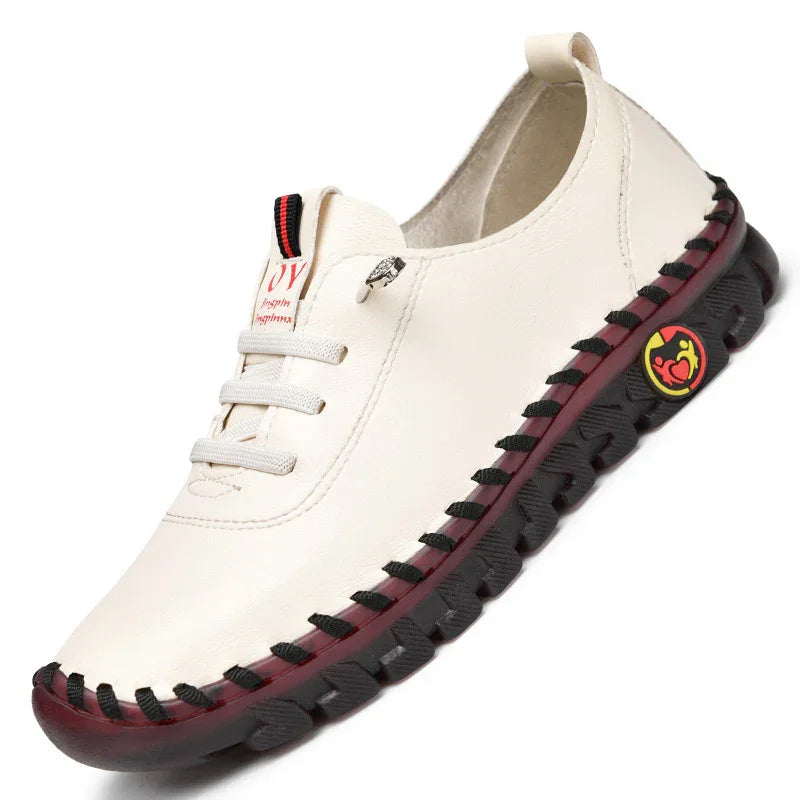 Casual cream leather slip-on shoe with black sole and red accents featuring a sporty logo
