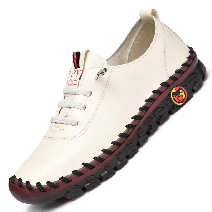 Casual cream leather slip-on shoe with black sole and red accents featuring a sporty logo