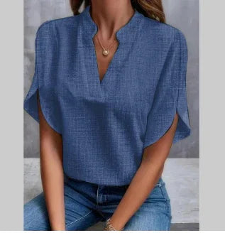 Woman wearing blue textured V-neck short sleeve blouse paired with blue jeans, casual outfit