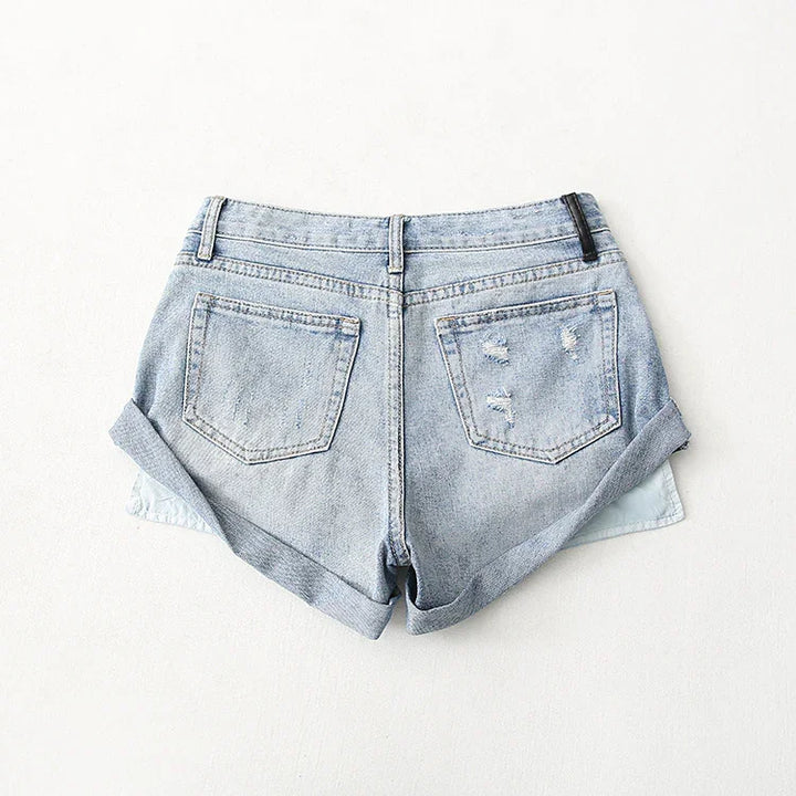 Back view of light blue distressed denim shorts with rolled cuffs on a white background