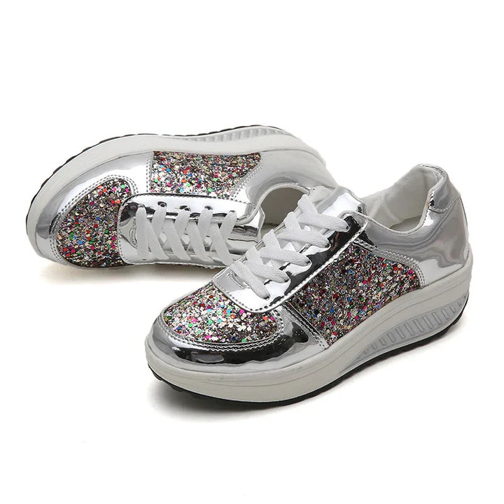 Silver platform sneakers with multicolor glitter panels and white laces on white background