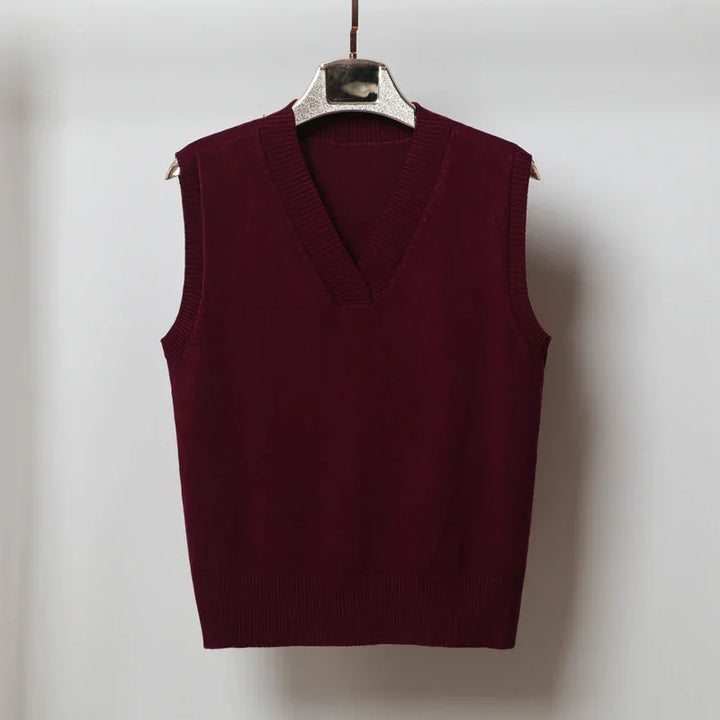 Maroon sleeveless V-neck knit sweater vest on hanger against plain background