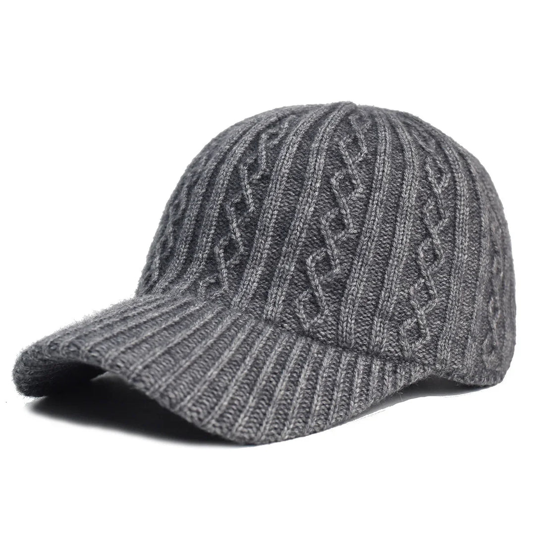 Gray knitted winter cap with cable knit pattern and curved brim on white background