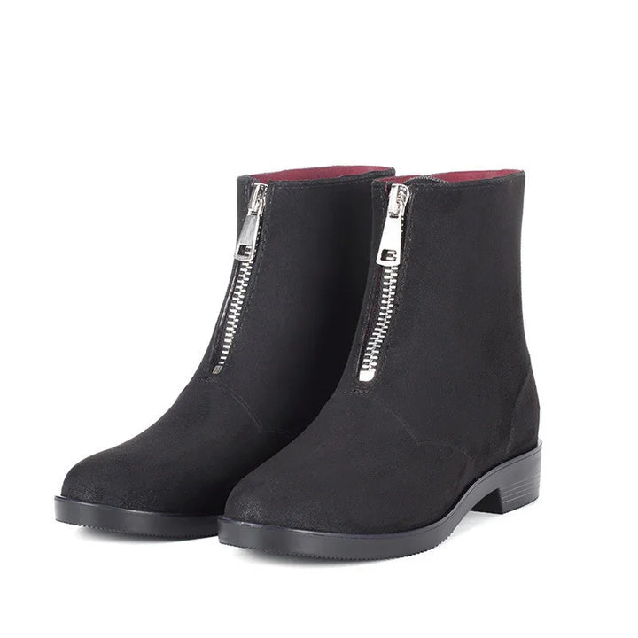 Pair of black suede ankle boots with front silver zipper and low heel on white background