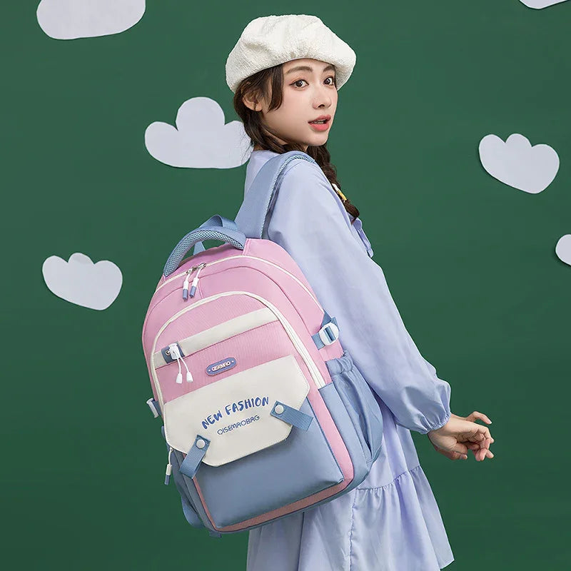Woman wearing a white beret and blue dress carrying a pink and blue backpack with NEW FASHION text