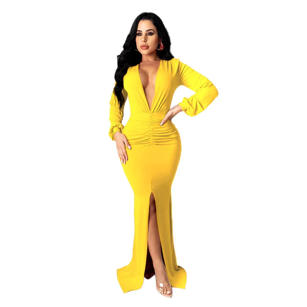 Woman in a yellow deep V-neck long sleeve dress with front slit and ruched waist posing
