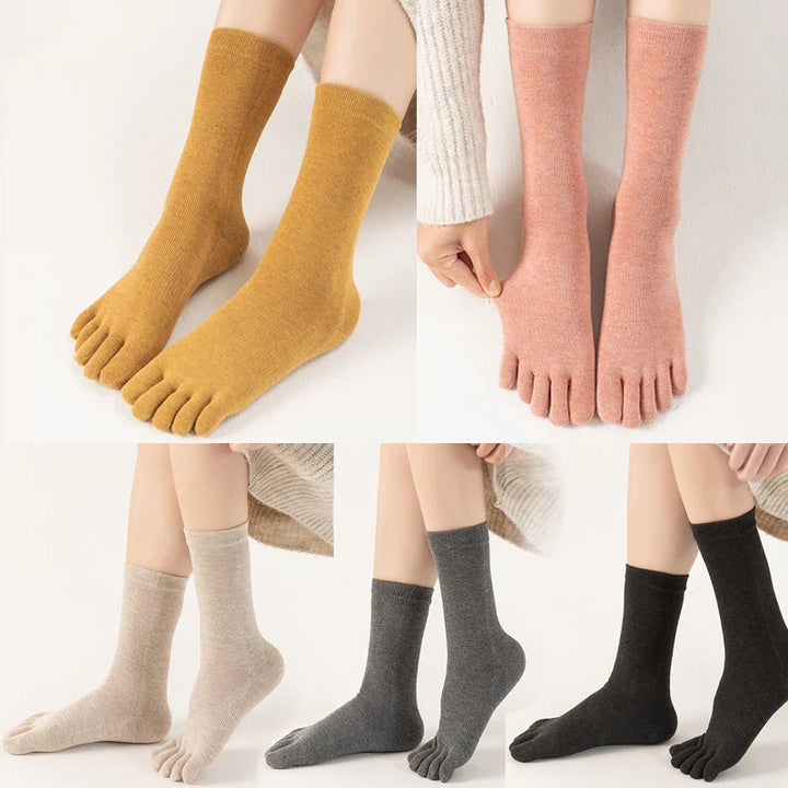 Five pairs of wool toe socks in mustard, pink, beige, gray, and black on white background