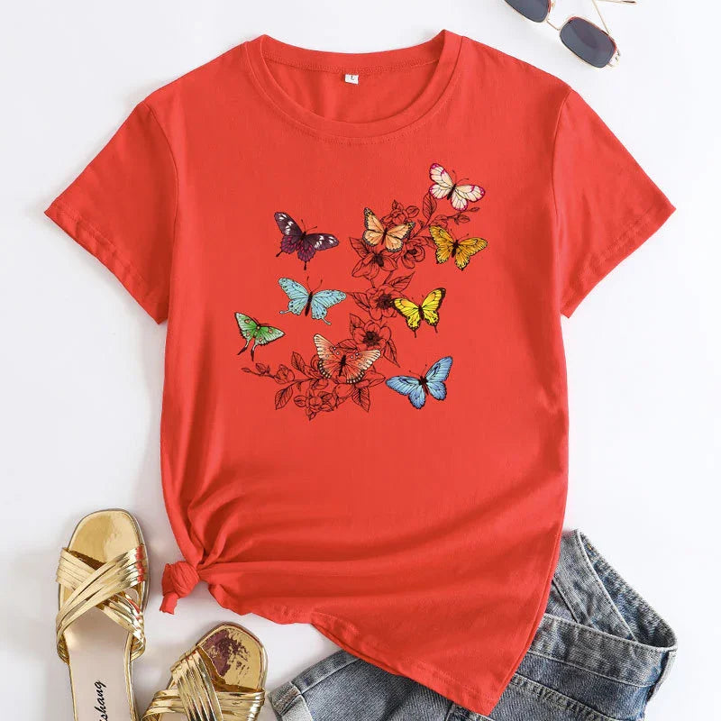 Red short-sleeve t-shirt with colorful butterfly and floral design paired with denim shorts and gold sandals