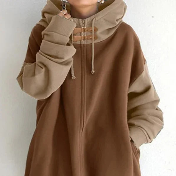 person wearing oversized brown and beige color-block hoodie with double buckle and drawstrings on hood