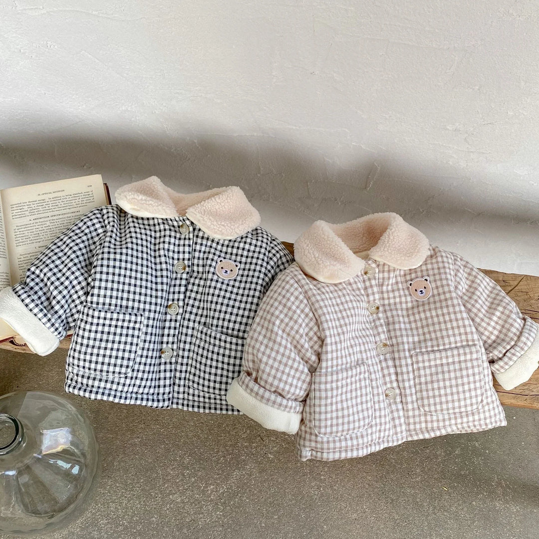 Two toddler checkered jackets in black and beige with sherpa collars and bear patches