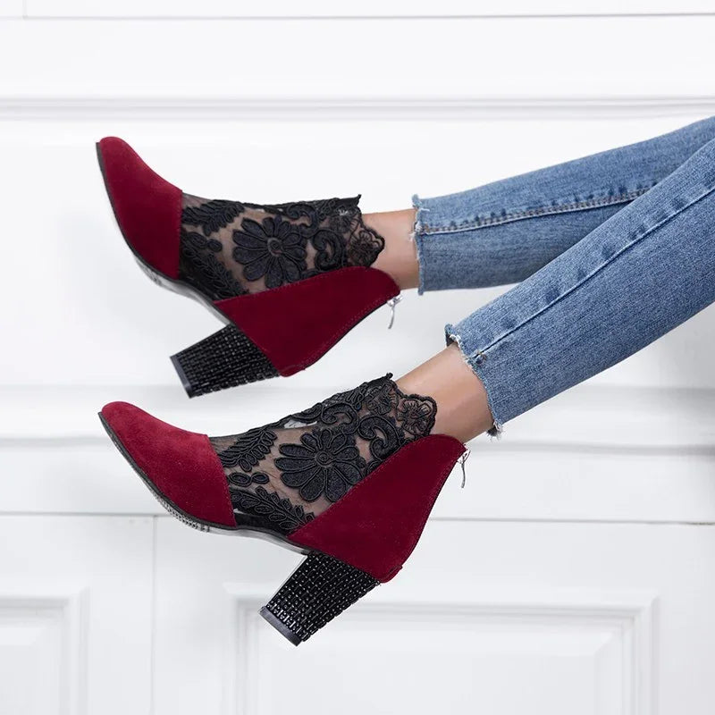stylish women's ankle boots with red suede and black floral lace mesh, worn with blue jeans