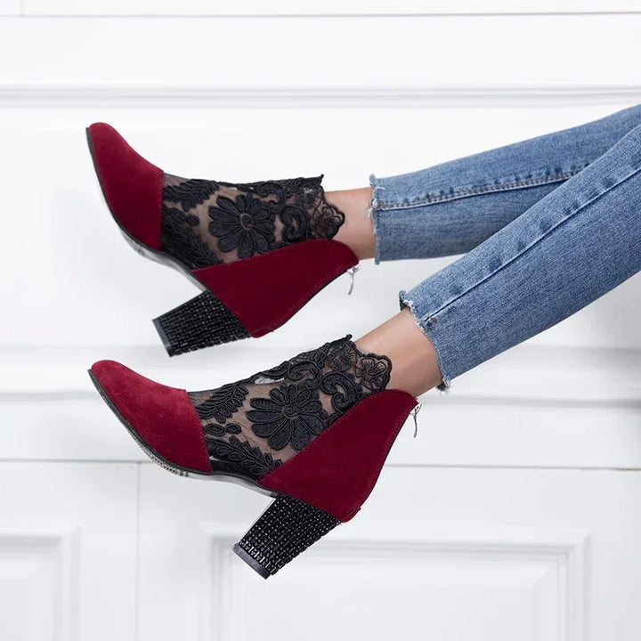 stylish women's ankle boots with red suede and black floral lace mesh, worn with blue jeans