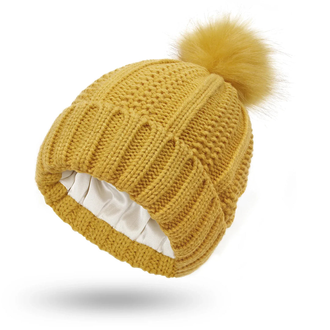 Mustard yellow knit winter beanie hat with pom pom and white satin lining