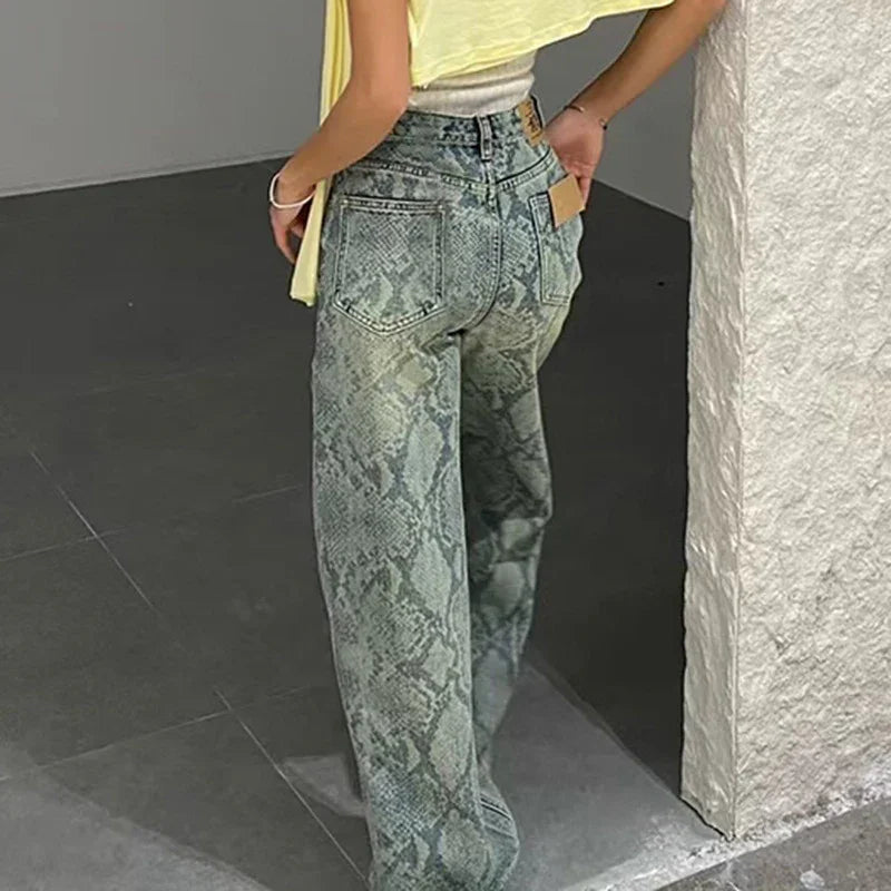 Person wearing high-waisted, wide-leg snake print jeans and a yellow top standing indoors