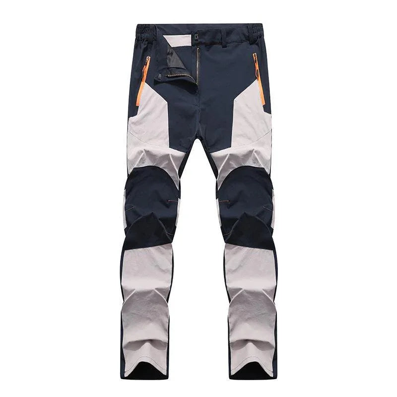 Men's outdoor hiking pants with black and light gray color blocks and orange zipper pockets