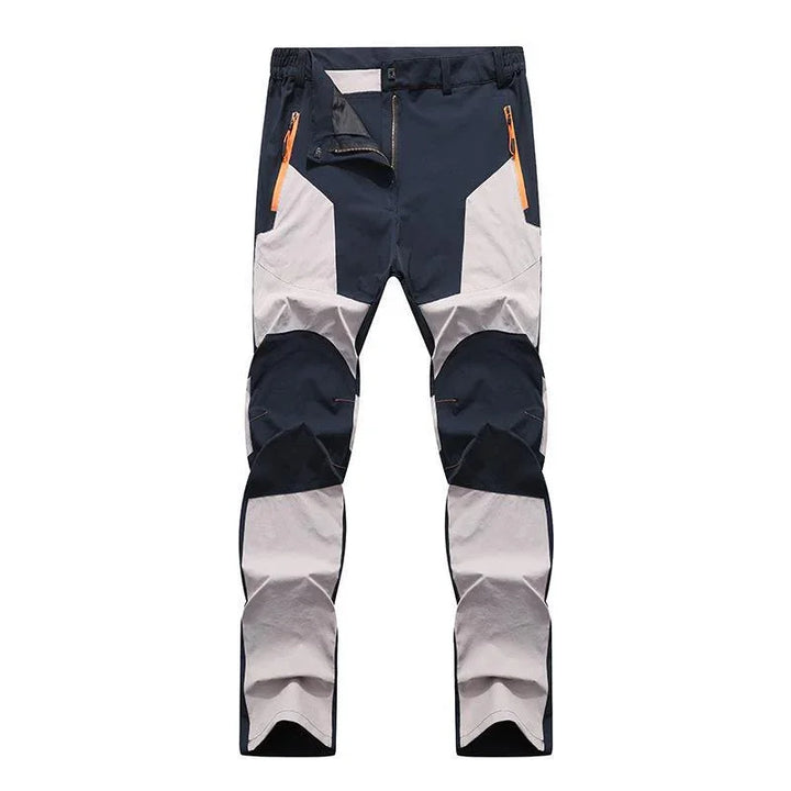 Men's outdoor hiking pants with black and light gray color blocks and orange zipper pockets