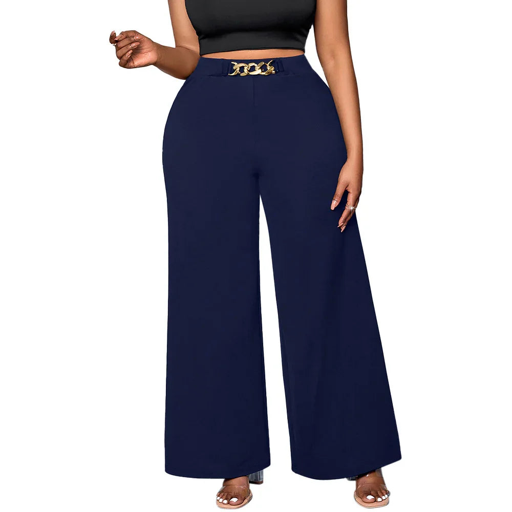 Woman wearing navy wide-leg pants with gold chain belt and black crop top