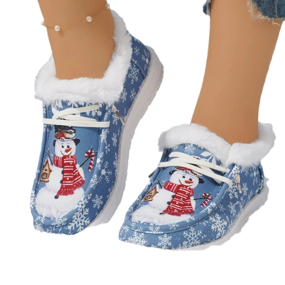 Cozy blue winter slippers with white fur trim and snowman design worn with ankle bracelet