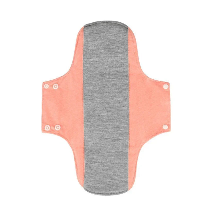 Reusable menstrual pad with grey center and coral pink wings, snap buttons for fastening