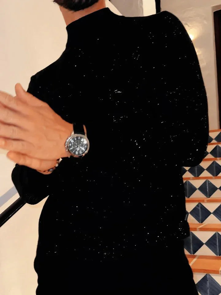 Man in black sweater wearing a silver wristwatch standing near blue and white tiled stairs